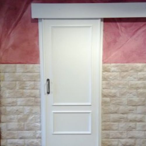 Puerta corredera lacada en blanco en baño de establecimiento hostelero